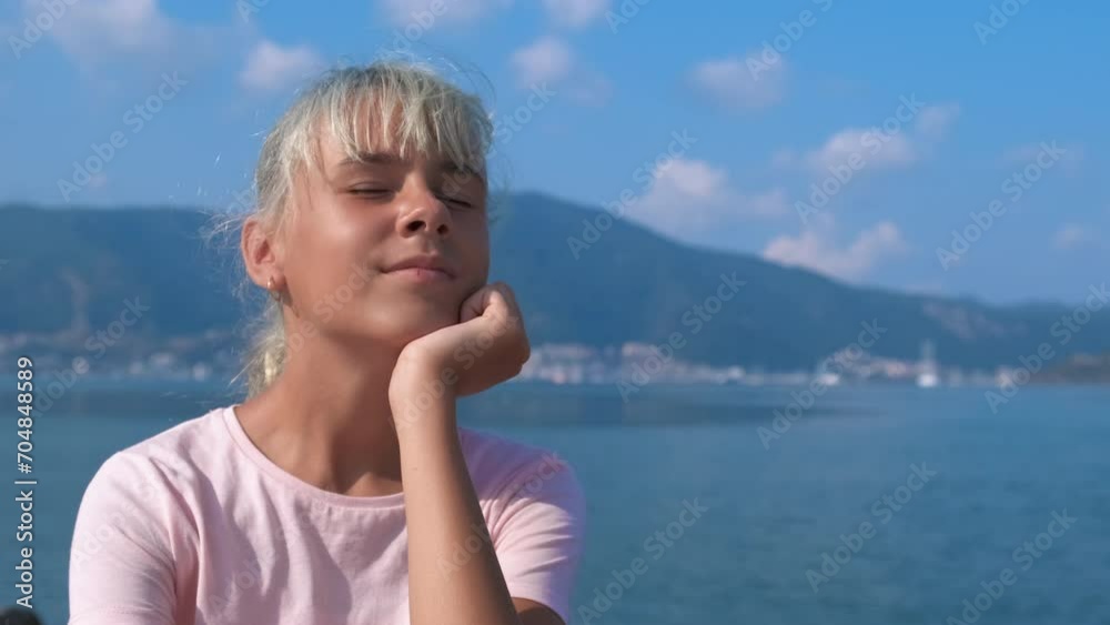 Enjoy the sea breeze. Happy girl closing her eyes enjoys the sea breeze. Enjoy the sea breeze. Happy girl closing her eyes enjoys the sea breeze.