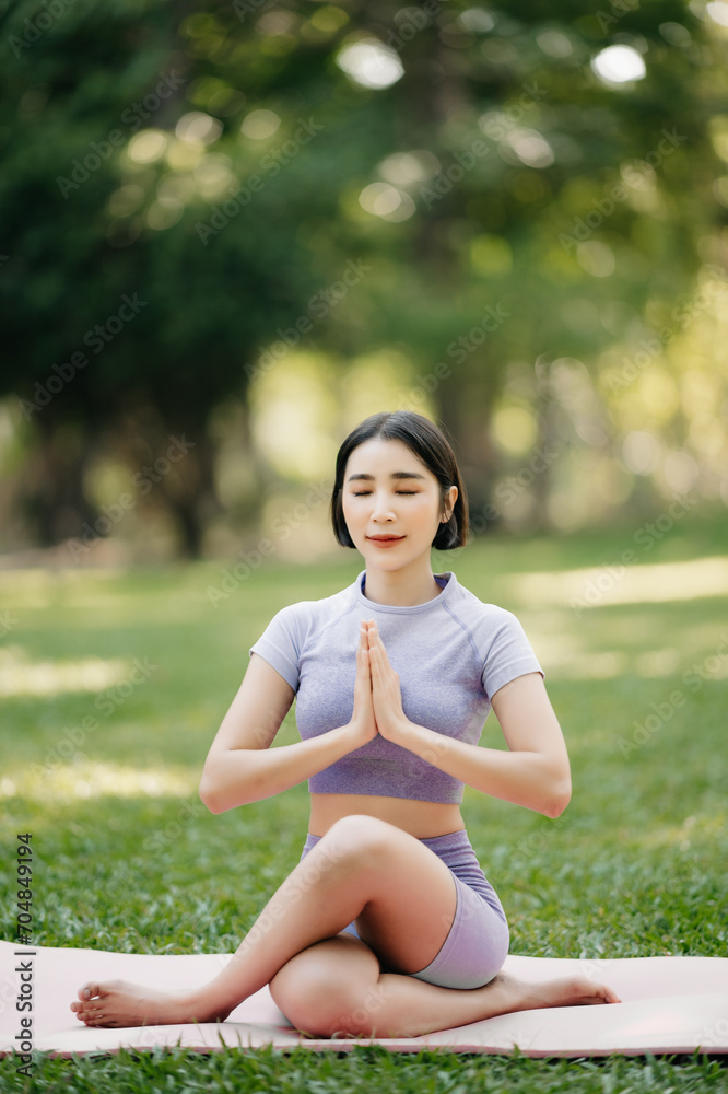 Portrait of young woman practicing yoga in garden.female happiness.  in the park blurred background.