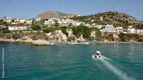 Drone footage of a boat sailing towards the Almyrida beach (Almirida beach) in Crete island, Greece photo