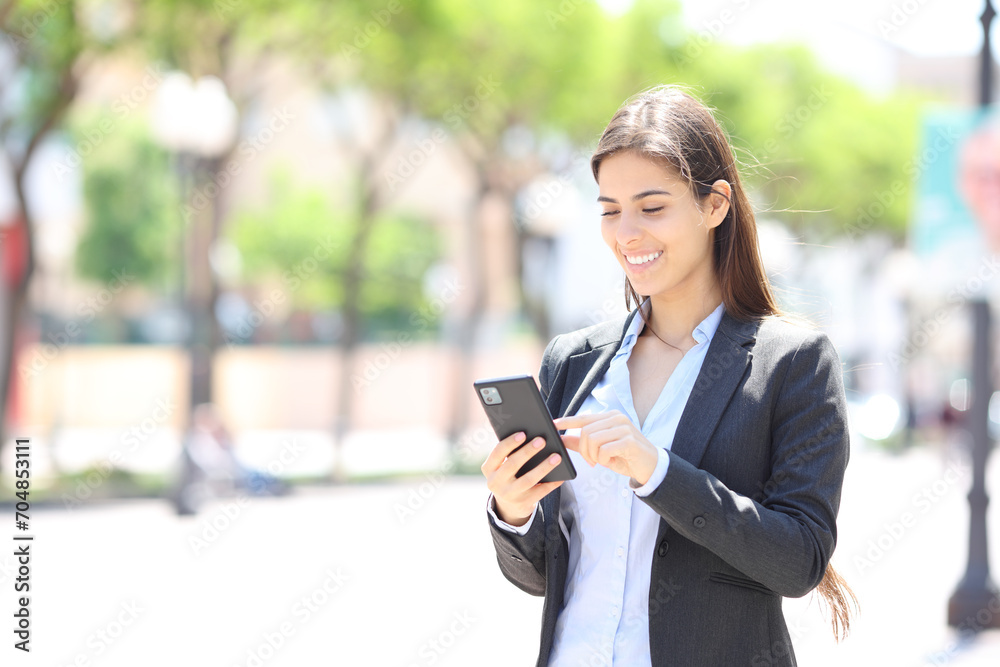 Happy executive is checking cell phone in the street Happy executive is checking cell phone in the street