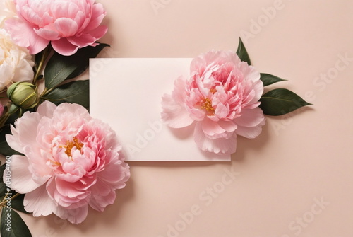 Greeting card mockup and beautiful pink peonies flowers frame on pastel beige background with copy space. Empty blank sheet card mock up for holiday greetings. Valentine's day, Mother's day, birthday