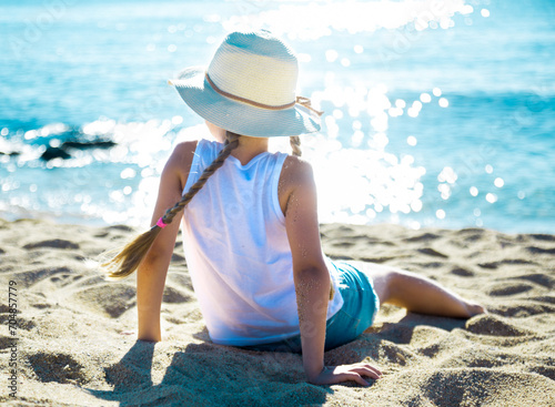 Child in ha enjoying on sandy beach of sea coast photo