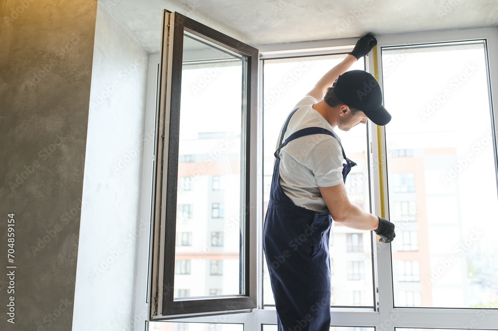 Construction worker repairing plastic window indoors, space for text. Banner design