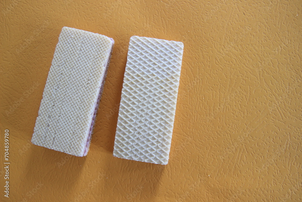 Obraz premium Two Vanilla Wafers on Orange Background