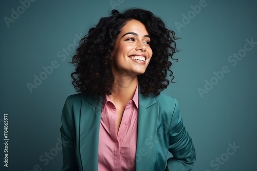 Portrait of a happy young business woman smiling at camera over blue background