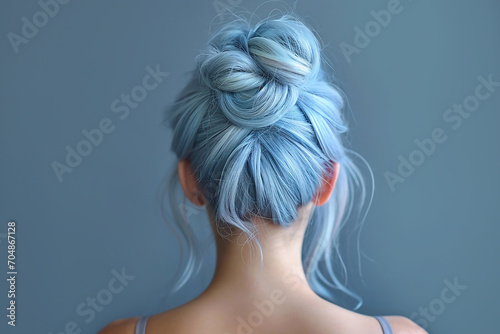 Portrait of a girl with blue hair with bun hairstyle on blue background close-up, rear view.