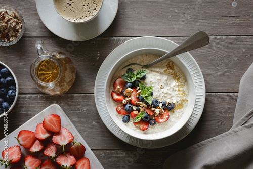 Studio shot of bowl of porridge with blueberries and strawberries photo