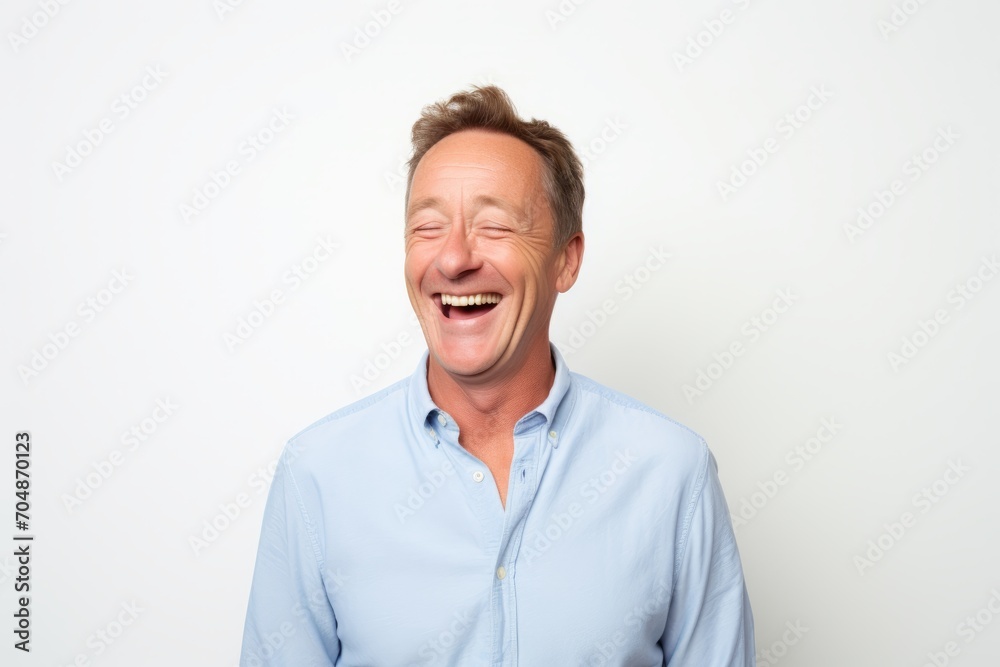 Portrait of a middle-aged man laughing against a white background Portrait of a middle-aged man laughing against a white background