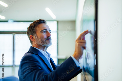 Businessman examining data on computer screen in office photo