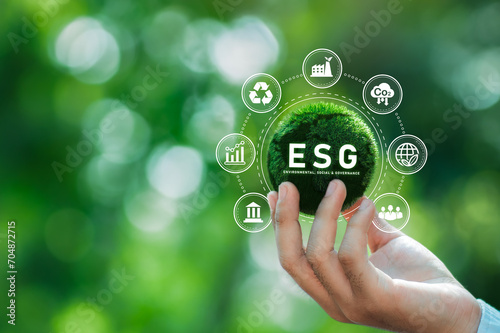 Hand of human holding green earth ESG icon for Environment Social and Governance.World sustainable environment concept on a green background.