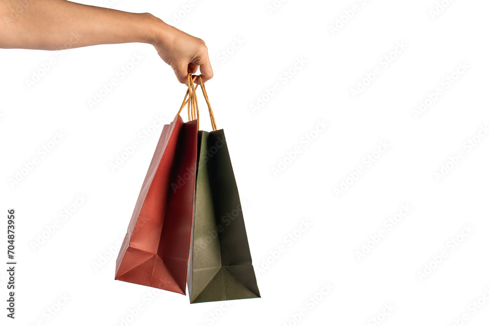 Red and green paper shopping bag in hand on transparent background.