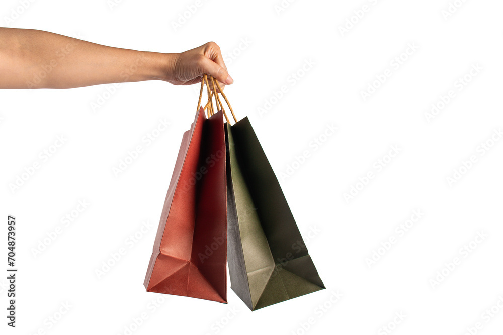 Red and green paper shopping bag in hand on transparent background.