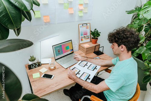 Web designer working with document and laptop in office photo