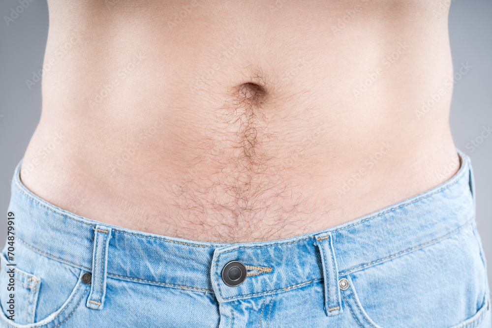 Naklejka premium Man in blue jeans on a gray background