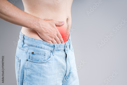 Stomach ulcer, man with abdominal pain on a gray background, symptoms of gastritis, diseases of the digestive system, bladder, pee-pee problem