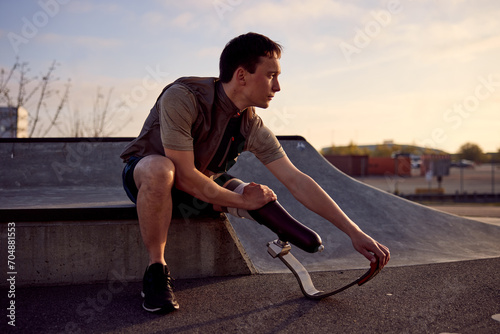 Fit man with a prosthetic blade stretching before a run photo