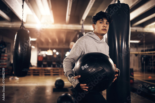 Young man working out with a medicine ball in a boxing gym photo