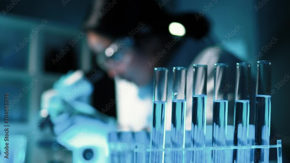 Lab assistant, a medical scientist, a chemistry researcher holds a glass tube through the blood sample, does a chemical experiment and examines a patient's blood sample. Medicine and research concept. Lab assistant, a medical scientist, a chemistry researcher holds a glass tube through the blood sample, does a chemical experiment and examines a patient's blood sample. Medicine and research concept.