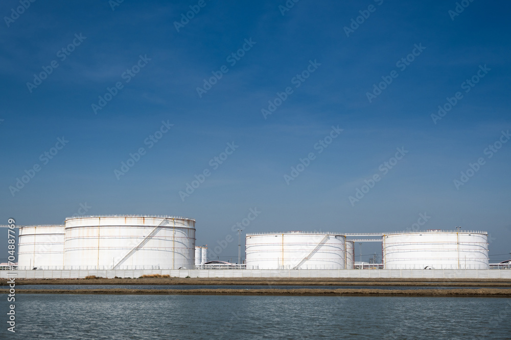 Obraz premium Large crude oil tanks are used to store crude oil, which is a type of unrefined petroleum. Crude oil is a thick, black liquid that is extracted from the ground