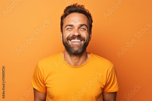 Portrait of a smiling man in orange t-shirt on orange background