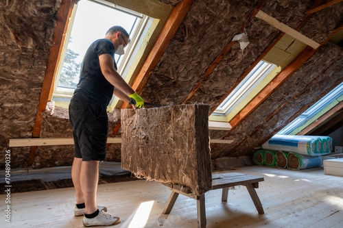 Canvas Print Craftsman cuts insulation material to insulate the attic.