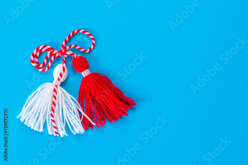 Bulgarian symbol of spring white and red martenitsa on blue background photo
