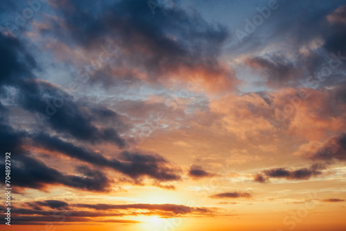 A vibrant sunset sky with a captivating array of orange hues painting a dramatic cloudscape  signaling the end of a day