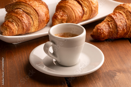Tazzina di caffè espresso italiano e cornetti, colazione europea 