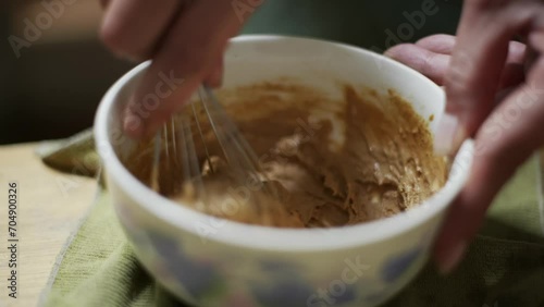 Thick peanut butter hand made paste whisked in bowl, filmed as close up slow motion shot photo