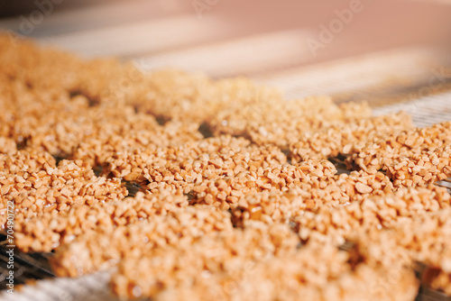 Process white milk chocolate on waffles with nuts on conveyor. Food industry Production line of modern bakery factory