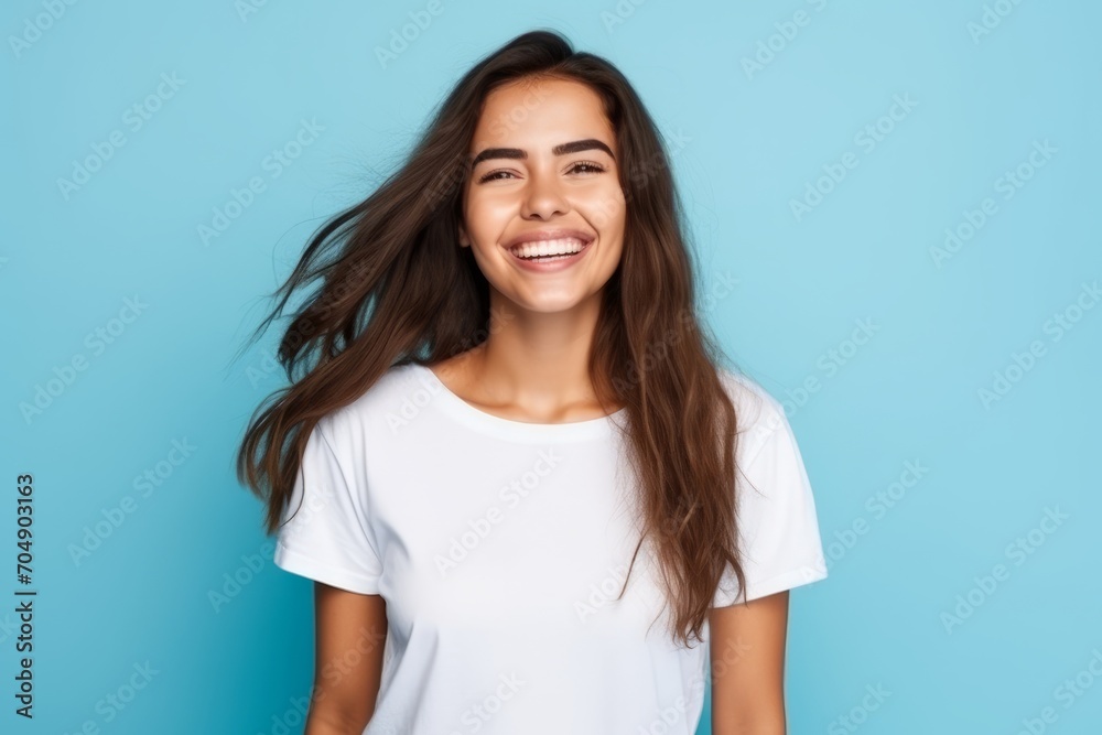 Portrait of a happy young woman with long hair over blue background Portrait of a happy young woman with long hair over blue background