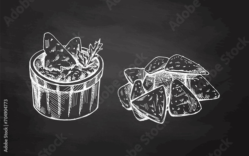 Hand-drawn sketches of bowl with guacamole, nachos and parsley leaves with a handful of nachos on chalkboard background. Vector food sketch. Illustration for menu. Latin America.