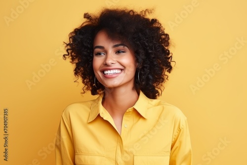 Portrait of a beautiful african american woman smiling over yellow background
