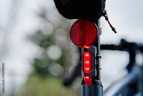 Glowing bicycle taillight. Red stop light for cyclist safety. Rear led light on bike photo