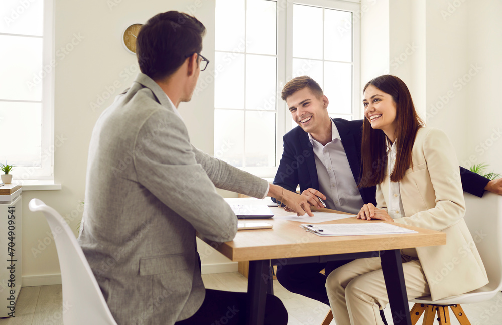 Obraz premium Group of business people or company employees sitting at the desk discussing something on workplace, reaching agreement and going signing a contract. Coworkers having a meeting in office.
