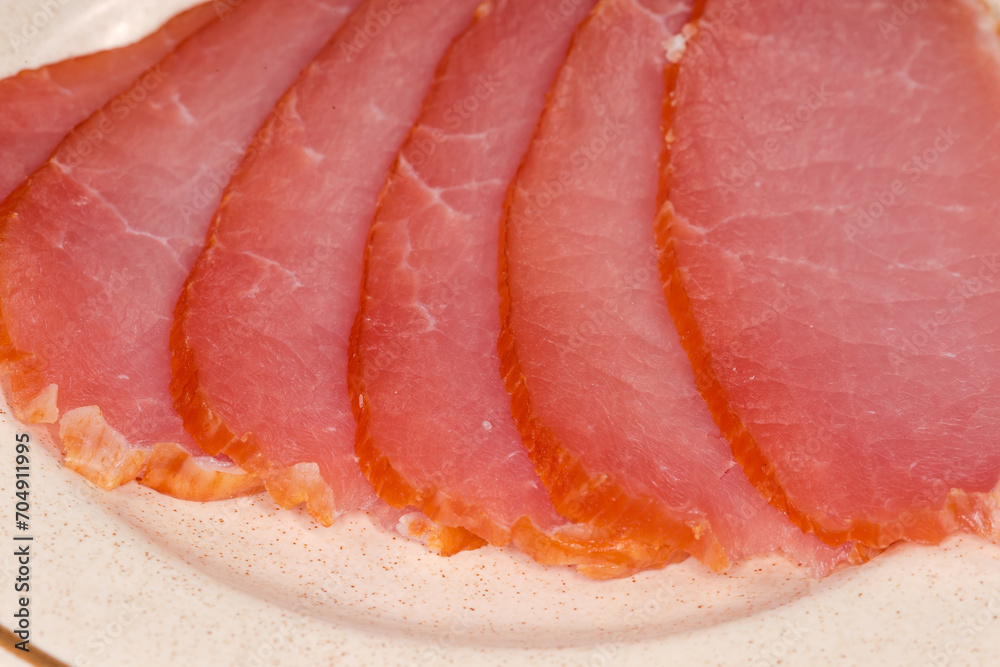Sliced dry-cured pork loin on saucer close-up