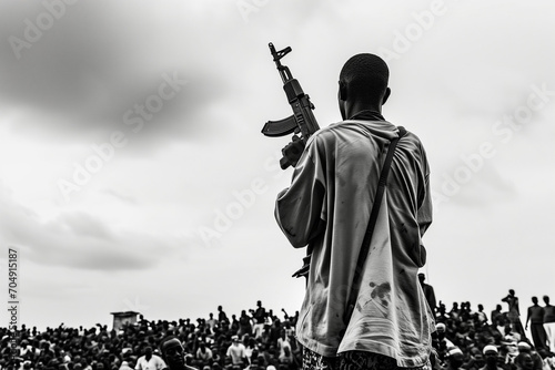 a man holding an ak47 looks down at the crowd, in the style of ndebele art, dramatic cityscapes, war photography, thx sound, jump cuts, black and white documentary photo