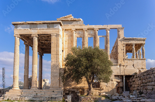 Ancient Erechtheion or Erechtheum temple in Acropolis of Athens. facade with olive tree at foreground. Athens, Greece photo