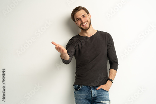 Positive young man pointing aside with fingers hand gesture at copy space advertising product, presenting sale discount standing isolated on white photo