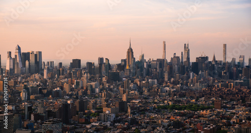 New York City Aerial Evening Cityscape with Stunning Manhattan Landmarks, Skyscrapers and Residential Buildings. Long Wide Angle Panoramic Helicopter View of a Popular Travel Destination
