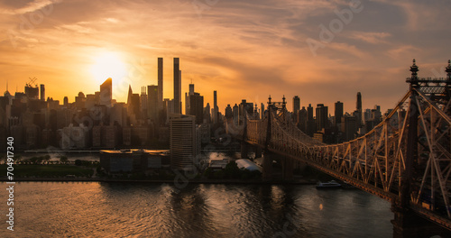 Aerial Helicopter Photo Over Ed Koch Queensboro Bridge with Manhattan Skyscrapers Cityscape. Beautiful Evening Sun Shining with Warm Sunset Light. Shot Focusing on Upper East Side Buildings