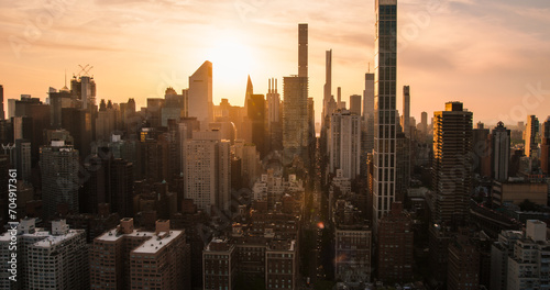 Beautiful Cinematic Aerial Sunset Shot of New York City Skyscrapers and Busy City Streets with Car Traffic. Panoramic Helicopter View of Lower Manhattan Office Buildings © Gorodenkoff