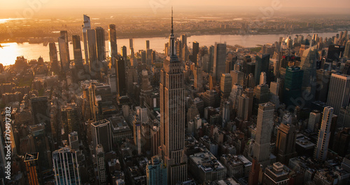 New York City Business Center From Above. Aerial Photo of a Famous Art Deco Skyscraper. Helicopter View on an Impressive Tourist Landmark. Manhattan Panorama with Empire State Building Spire photo