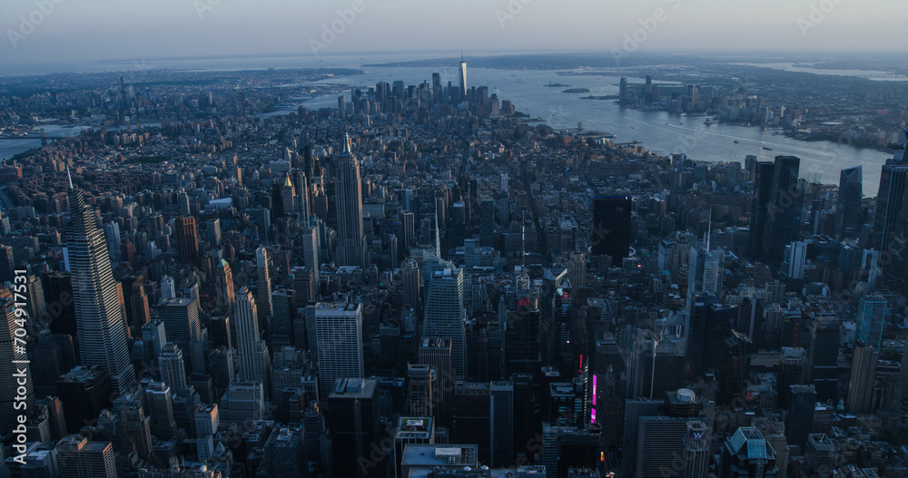 Fototapeta premium Desaturated Aerial Evening Shot of New York City with Endless Busy Roads, Streets with Cars and Commercial Vehicles. Panoramic View of Office Buildings and Skyscrapers in a Big Urban District