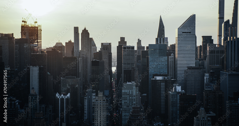 Moody Cinematic Aerial Sunset Image of New York City Skyscrapers and Busy City Streets with Car Traffic. Panoramic Helicopter View of Lower Manhattan Office Buildings