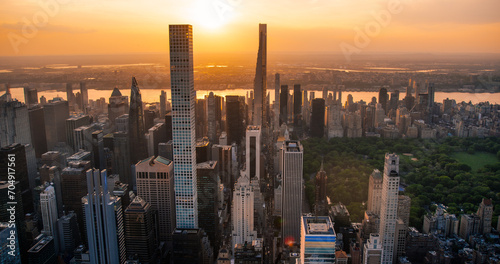 New York Cityscape at Sunset. Aerial Shot from a Helicopter. Modern Skyscraper Buildings with Central Park in Manhattan Island. Focus on City Architecture Next to Park