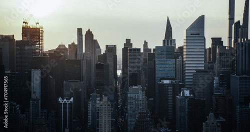 Moody Cinematic Aerial Sunset Image of New York City Skyscrapers and Busy City Streets with Car Traffic. Panoramic Helicopter View of Lower Manhattan Office Buildings