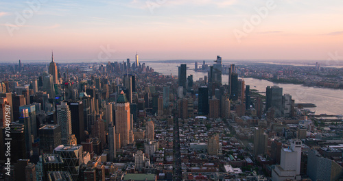 Fototapeta Naklejka Na Ścianę i Meble -  New York City Aerial Evening Cityscape with Stunning Manhattan Landmarks, Skyscrapers and Residential Buildings. Long Wide Angle Panoramic Helicopter View of a Popular Travel Destination