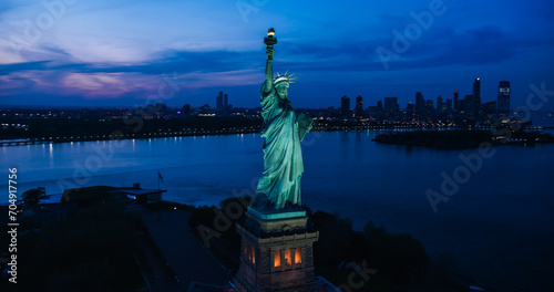 Aerial Helicopter Cinematic View of the Statue of Liberty with Manhattan Skyline Cityscape in the Evening. Panoramic View of New York City Skyscrapers and Jersey City Buildings at Sunset © Gorodenkoff