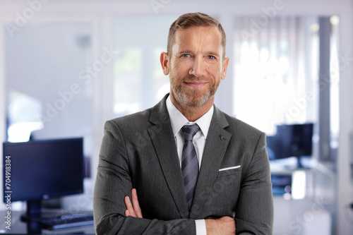 Portrait of mid aged businessman standing at the office